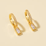 Load image into Gallery viewer, Gold hoop earrings with rectangular gemstones on a beige background