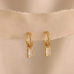 Load image into Gallery viewer, Gold hoop earrings with rectangular gemstones on a beige fabric background