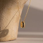 Load image into Gallery viewer, Gold necklace with a pendant on a textured surface