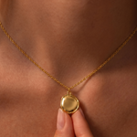 Load image into Gallery viewer, Gold necklace with a round pendant on a person's neck