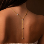 Load image into Gallery viewer, Gold necklace with small diamonds on a person's back against a brown background