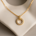 Load image into Gallery viewer, Gold plated necklace with a circular pendant on a neutral background