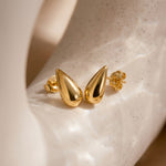 Load image into Gallery viewer, Gold teardrop earrings on a speckled beige surface