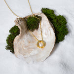Load image into Gallery viewer, A luxurious product shot of a gold and pearl circle necklace. This beautiful piece of minimalist jewellery from Zewory is artistically arranged inside a large seashell on a bed of white sand, highlighting its modern elegance.