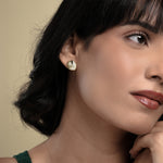 Load image into Gallery viewer, A close-up of a model wearing a delicate gold seashell stud earring from Zewory Jewellery. The detailed, ribbed scallop shell design sits elegantly on her earlobe, showcasing a chic, ocean-inspired accessory.