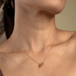 Load image into Gallery viewer, A close-up of a model wearing a delicate rose gold necklace with a symbolic interlocking rings pendant. The minimalist double-circle design sits elegantly against her skin, showcasing a timeless and meaningful piece of fashion jewellery.