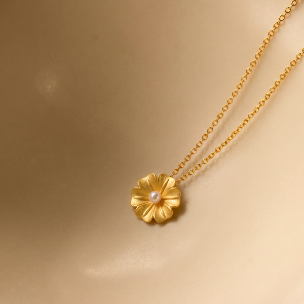 18k Gold plated necklace with a floral pendant on a gold background