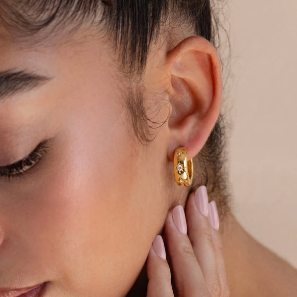 Gold star pave huggie hoop earring in 14K gold-plated sterling silver worn on a model, featuring sparkling star accents for an elegant everyday look