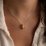 Load image into Gallery viewer, Close-up of a person wearing a gold plated necklace with a pendant.

