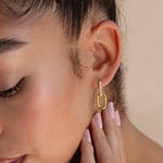 Load image into Gallery viewer, Close-up of a woman wearing a gold hoop earring with a blurred background
