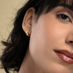 Load image into Gallery viewer, Close-up of a woman wearing a gold earring with a neutral background
