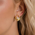 Load image into Gallery viewer, Gold earring with pearl detail worn by a person with blonde hair.

