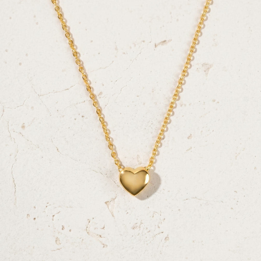 Gold heart-shaped pendant necklace on a light background