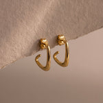 Load image into Gallery viewer, Gold hoop earrings on a textured beige surface
