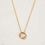 Load image into Gallery viewer, Gold necklace with a pearl pendant on a light beige background
