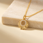 Load image into Gallery viewer, Gold necklace with a sunflower pendant on a beige surface
