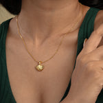 Load image into Gallery viewer, A close-up of a model wearing a delicate gold seashell necklace from Zewory Jewellery. The elegant, ribbed scallop shell pendant is showcased against her dark green top, perfect for a chic, ocean-inspired look.
