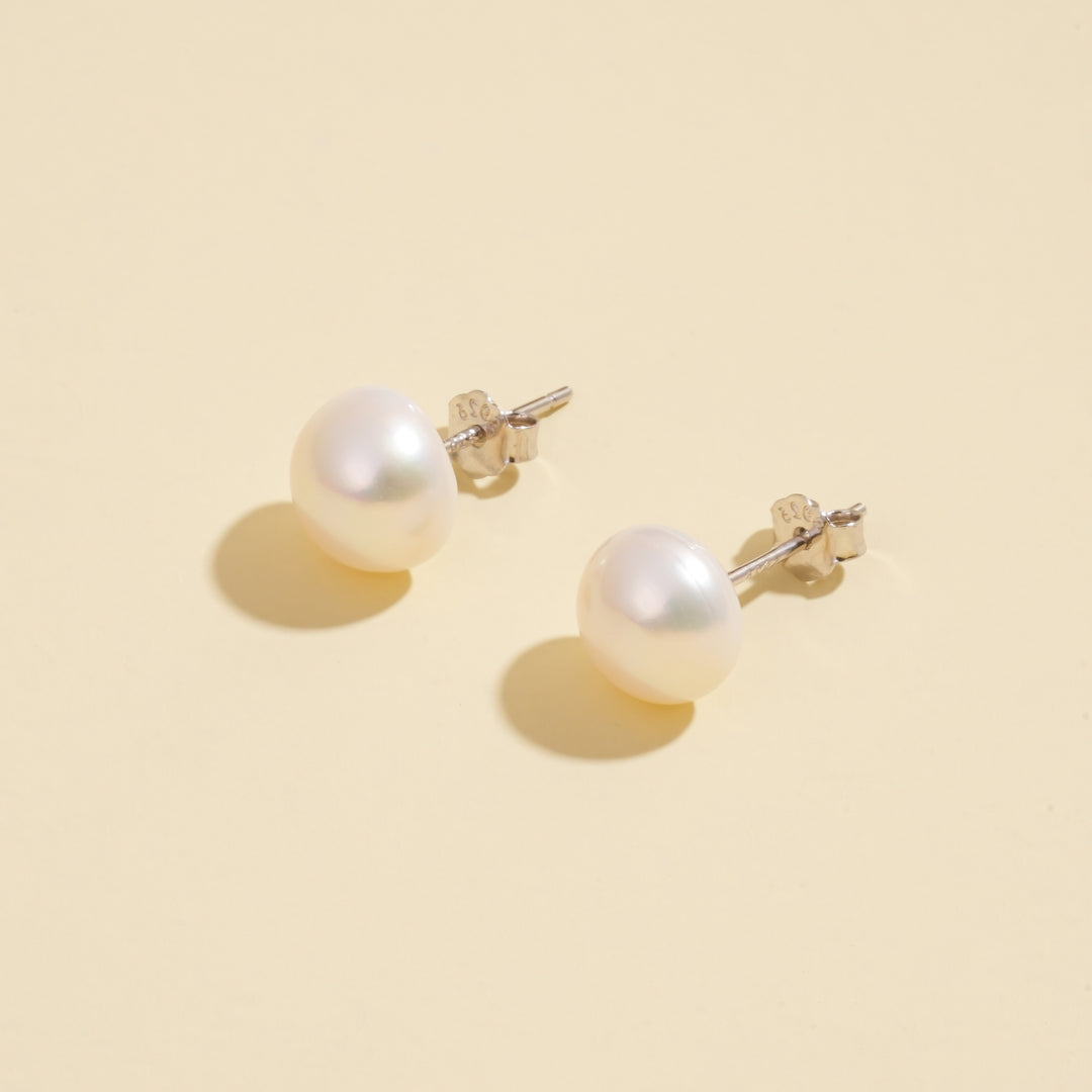 Pearl earrings on a beige background