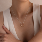 Load image into Gallery viewer, Person wearing a delicate gold necklace with a minimalistic pendant against a neutral background
