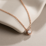 Load image into Gallery viewer, Rose gold necklace with a diamond pendant on a beige surface
