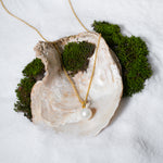 Load image into Gallery viewer, White pearl pendant necklace with gold chain from Zewory Jewellery displayed on a seashell.

